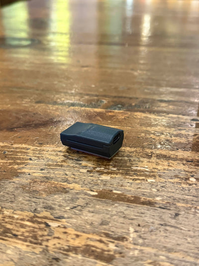 Black Phreno head-impact sensor on a wooden tabletop